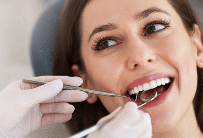 Woman smiling while getting her teeth worked on, representing dentists in Lansdowne