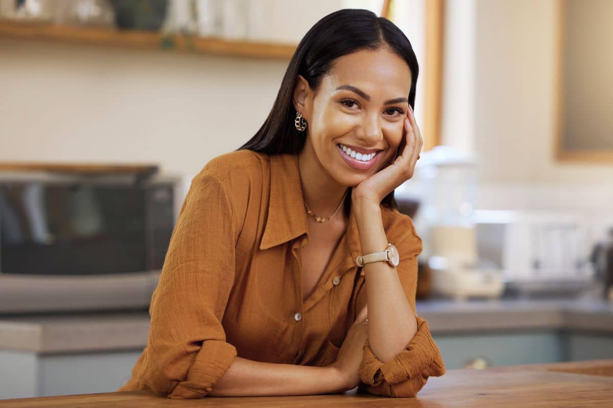 Woman leaning on counter smiling lansdowne dentistry by design teeth whitening