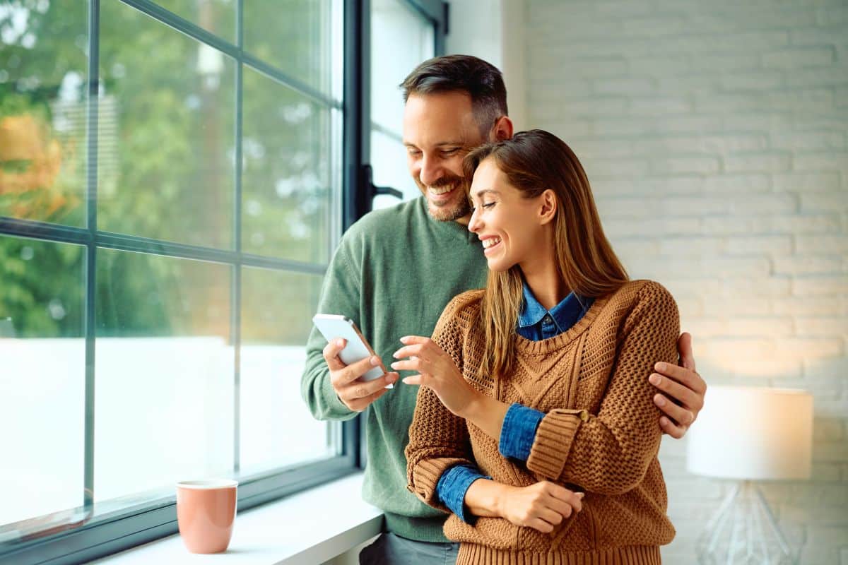 couple smiling by window patient testimonials lansdowne dentistry by design