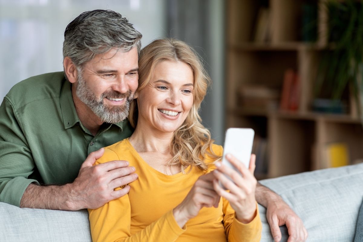 Happy couple reviewing dental plan options at home in Lansdowne, VA